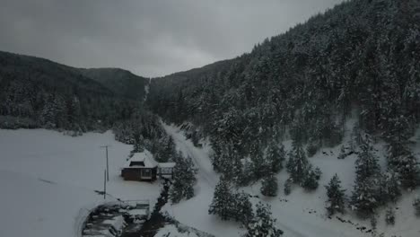 Dichter-Nadelwald-Und-Berghaus-Mit-Schnee-Bedeckt