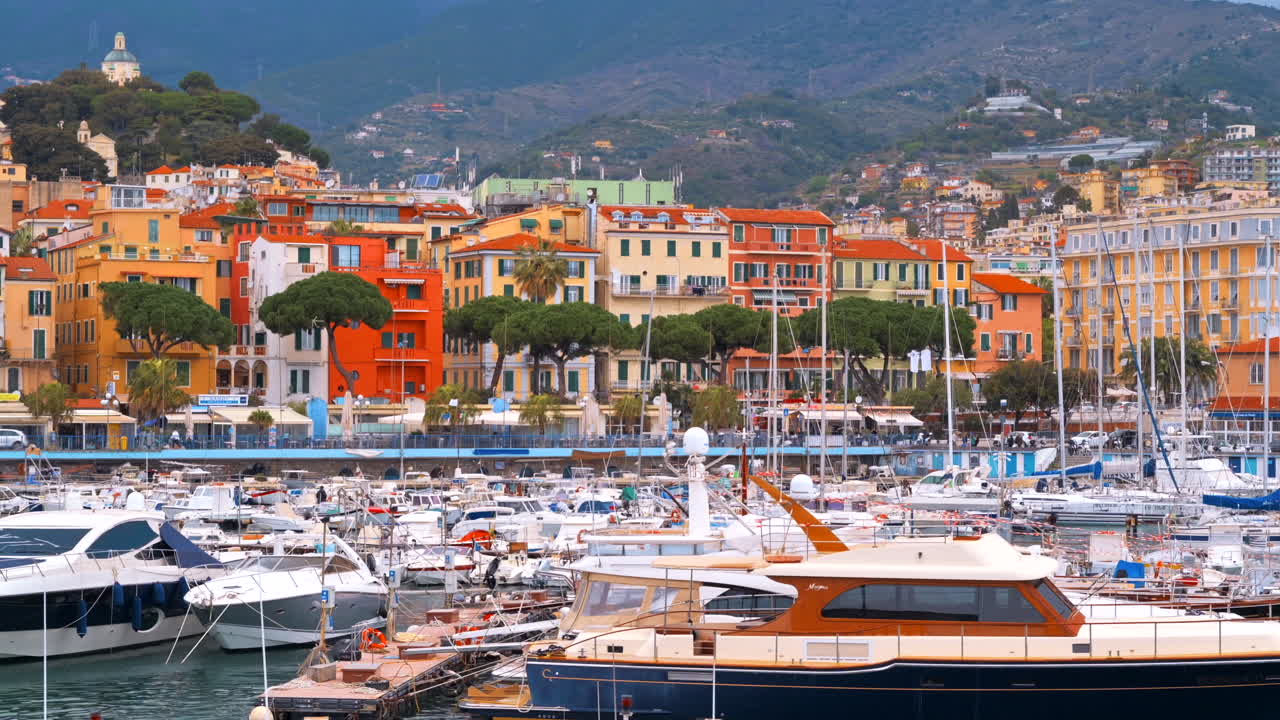 Porto marittimo mediterraneo con numerosi yacht e barche ormeggiati, edifici classici sullo sfondo a Sanremo, Italia