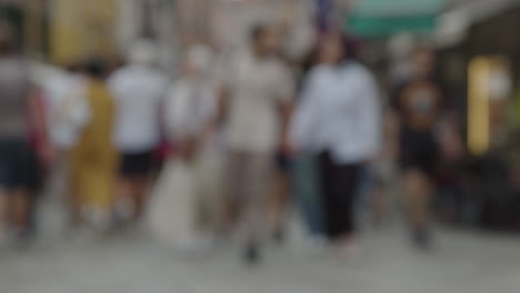 multitud borrosa de personas caminando por una calle de la ciudad