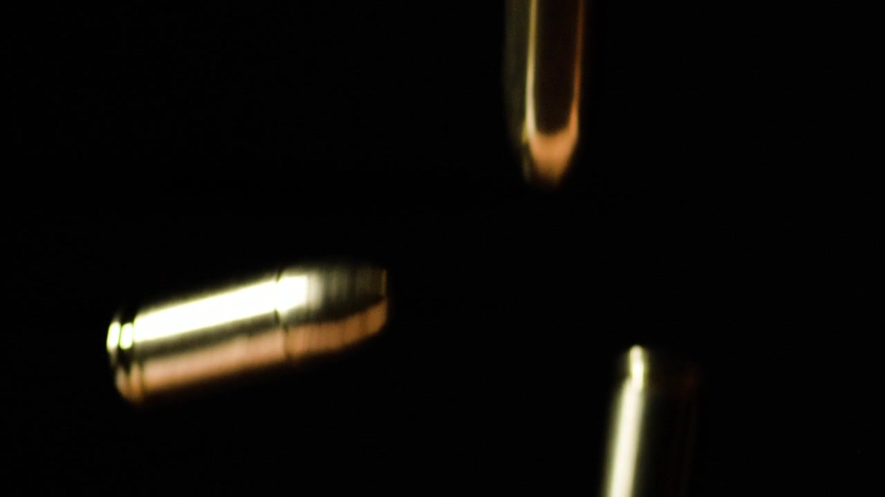 balas parabélicas de 9mm caindo em câmara lenta contra fundo preto, macro