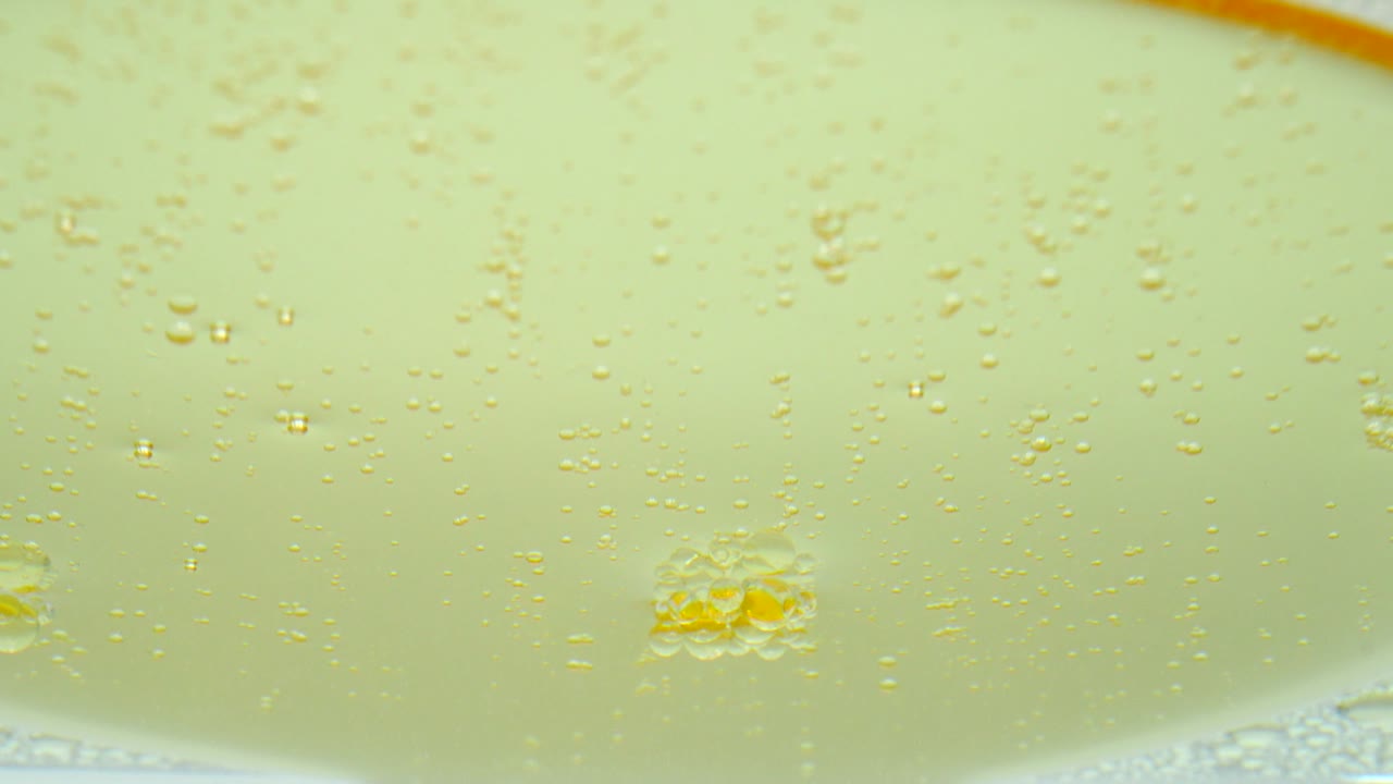 배경으로 물 표면에 떠다니는 노란색 기름.