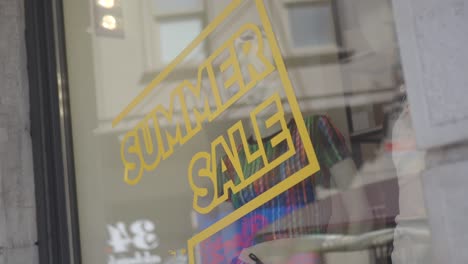 summer sale sign displayed on a shop window