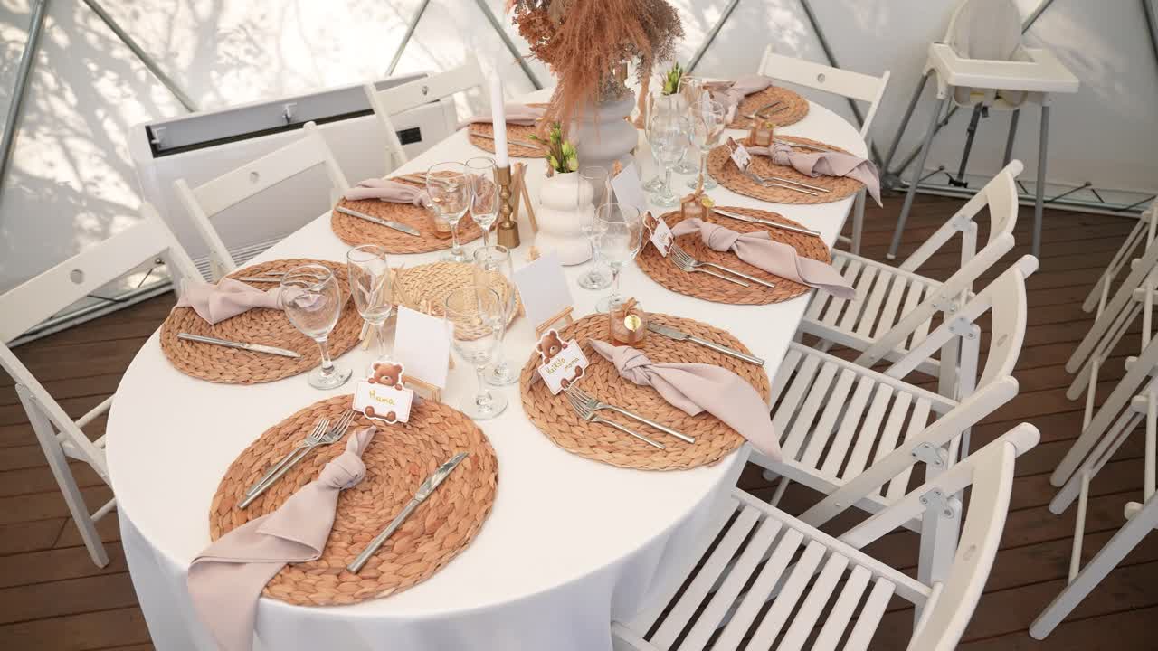 Beautiful baby shower or birthday table setup with woven placemats, teddy bear name cards, and soft neutral decor inside a white dome, perfect for a cozy and elegant celebration