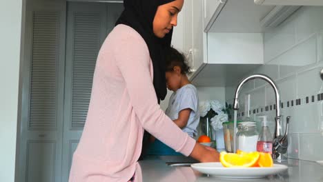 Young-mother-washing-dishes-in-kitchen-at-home-4k