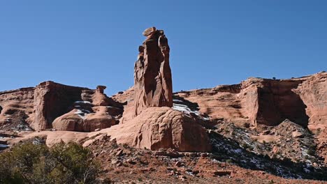 driving past sheep rock in arches national park during the day