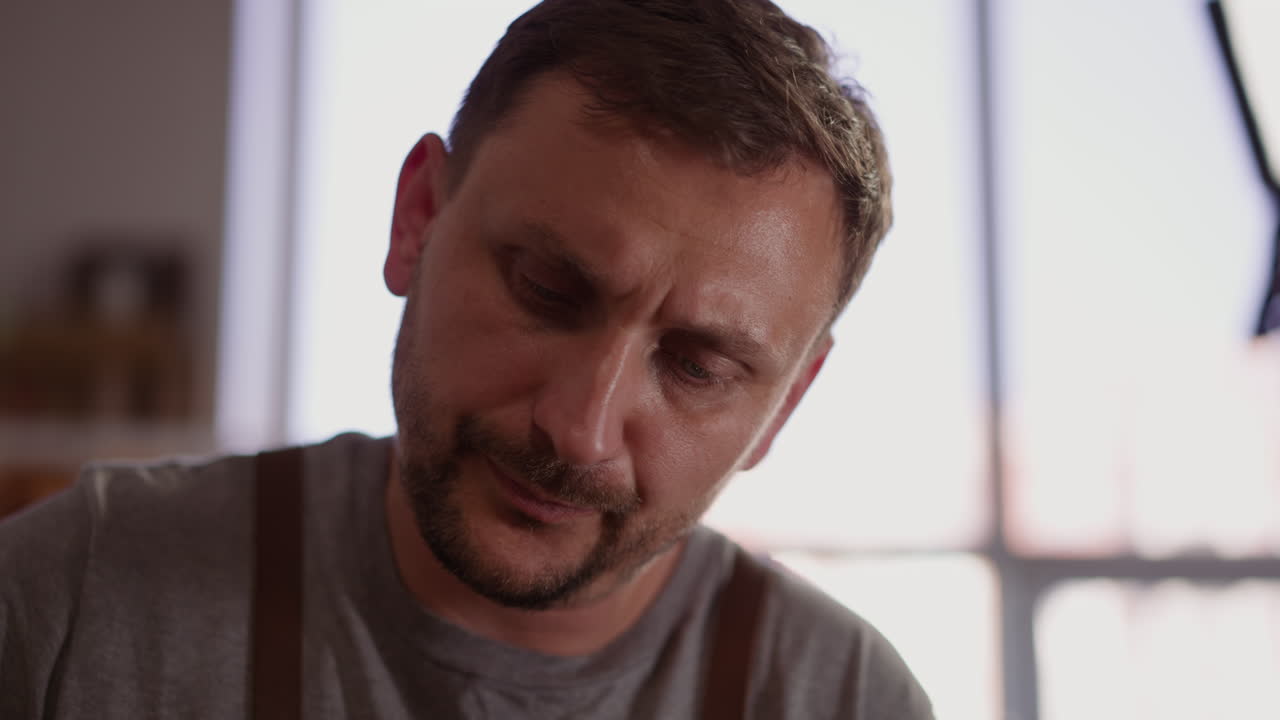 trabajador con rastrojo de tres días en un taller de artesanía de cerca