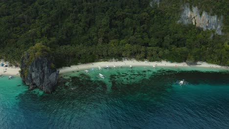 WS-AERIAL-Seascape-with-beach,-forest-and-boats,-El-Nido,-Palawan,-Philippines