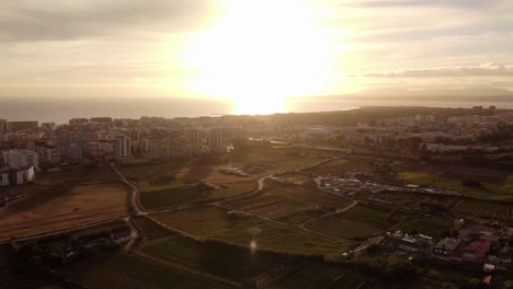 hermosa toma de drones de costa da caparica con brillante puesta de sol en el horizonte en portugal