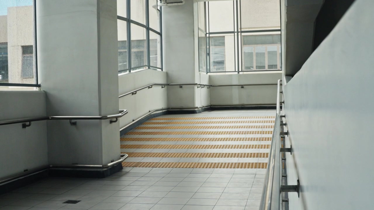Un plano medio de una rampa dentro de una estación de tren moderna, mostrando líneas arquitectónicas limpias y un diseño funcional