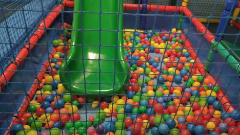 tobogán en la piscina de bolas con red y protección de espuma a los golpes en el centro de ocio y parque infantil interior muy colorido, disparando a la muñeca que viaja hacia atrás, órdenes, galicia, españa