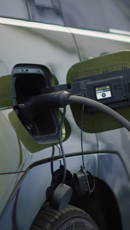 vertical video close up shot of electric suv automobile charging at modern station