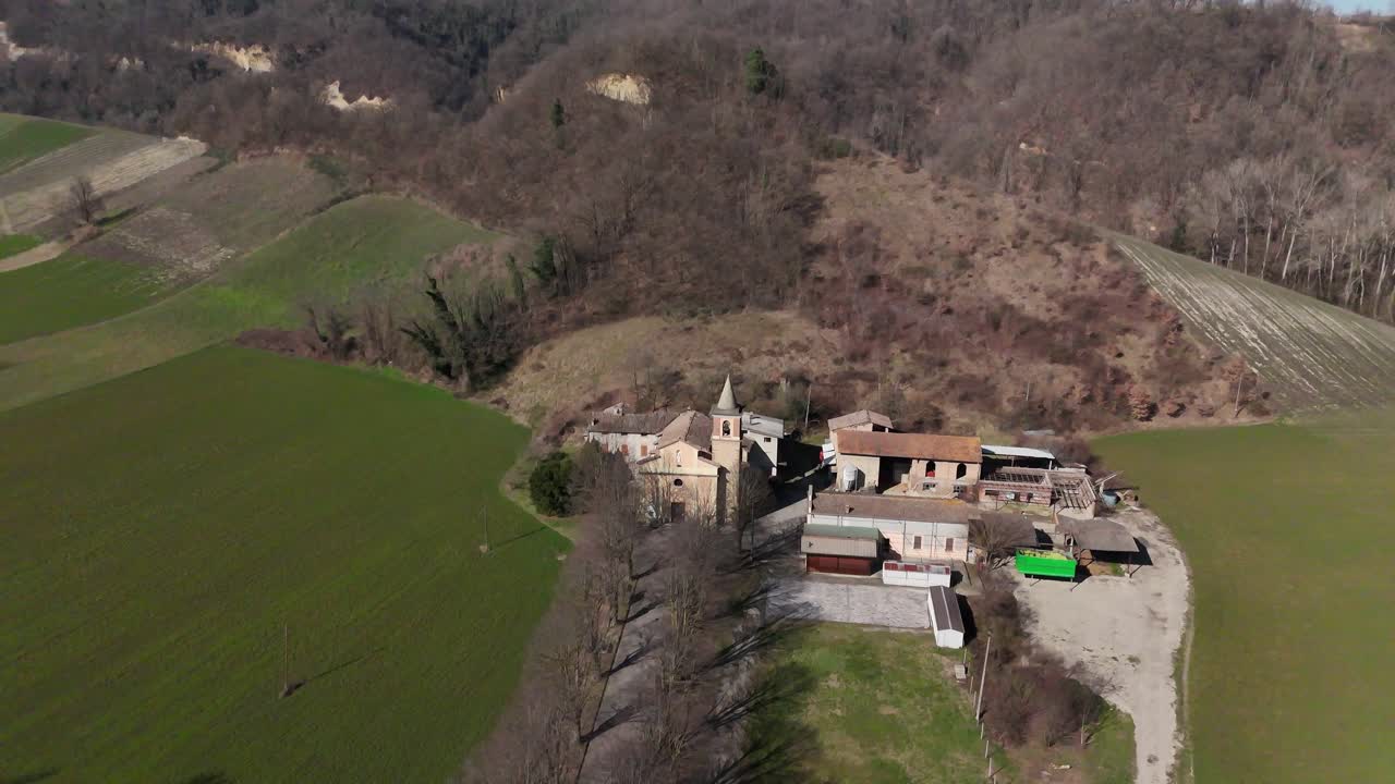 Chiesa di Sant'Ilario Vescovo all'interno del borgo rurale di Chiavenna Rocchetta vicino a Lugagnano Val d'Arda, Provincia di Piacenza, Emilia-Romagna, Italia — aerea statica