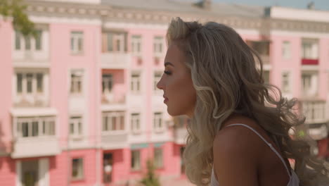 seductive woman with hairdo enjoys city view on terrace