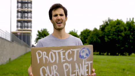 close up of a handsome man talking and holding a placard