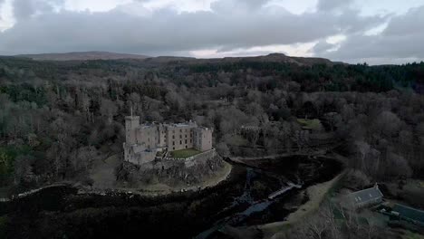 Castillo-De-Dunvegan-En-La-Isla-De-Skye-Rodeado-De-Bosques-En-Tiempo-Nublado,-Vista-Aérea