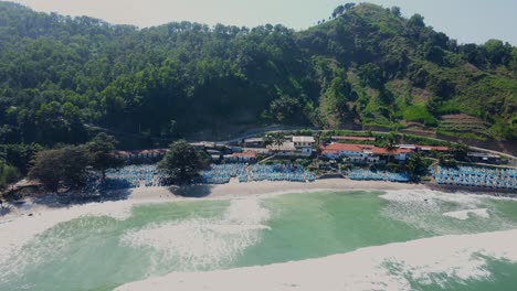 Vista-Aérea-De-Muchos-Barcos-De-Pescadores-Estacionados-En-La-Playa-Frente-A-Verdes-Colinas-En-Java-Central,-Indonesia