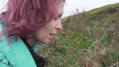 cerrar la toma en cámara lenta de una hermosa chica, mujer con viento en el pelo, probando una mora en la naturaleza que le pone una sonrisa en la cara