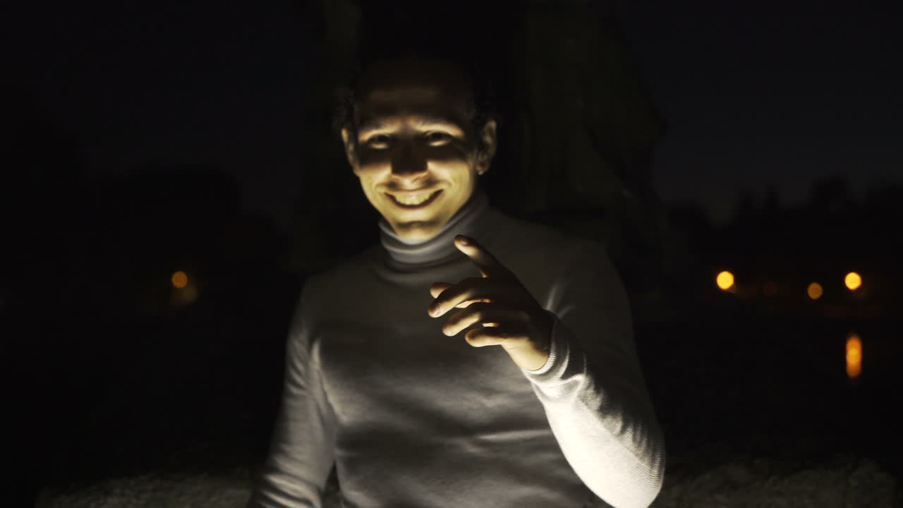 Scary smiling face in the dark, illuminated by light