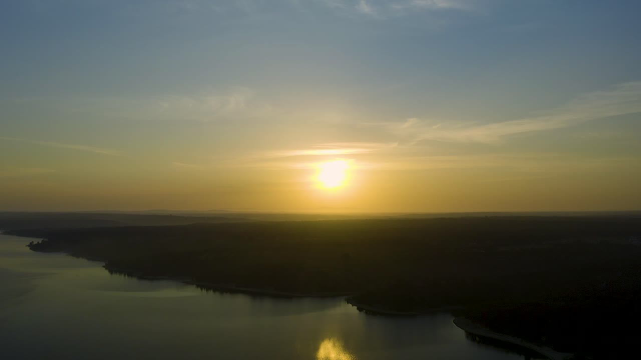 Wide and beautiful view of sun over dam on a huge sunrise in Alentejo, Portugal