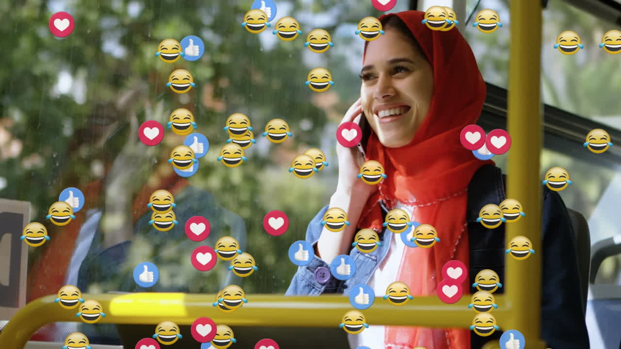 animación de emojis que caen sobre una mujer con hijab usando un teléfono inteligente