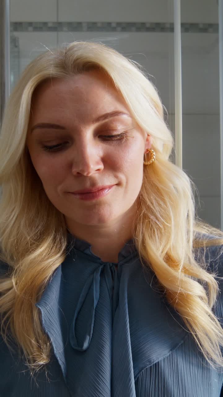 Woman adjusting earrings in a bathroom