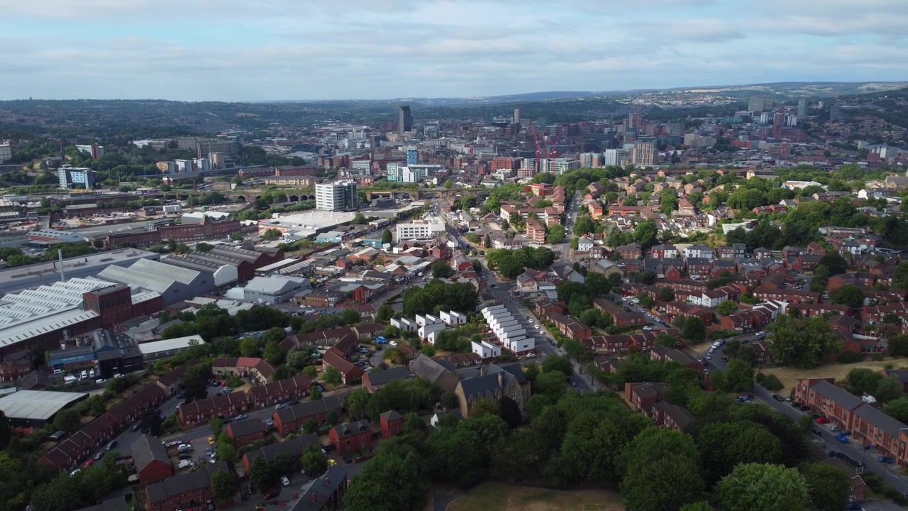 Ripresa aerea con drone con un leggero movimento di parallasse che si affaccia sul centro di Sheffield da Burngreave in una giornata di sole con nuvole sparse. Skyline urbano nel South Yorkshire, Inghilterra.