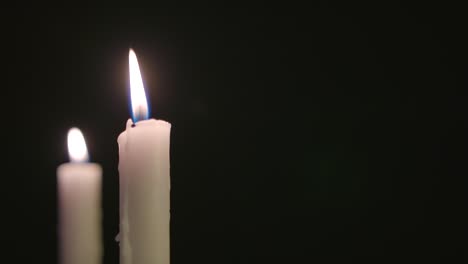 two white candles burning in slow motion