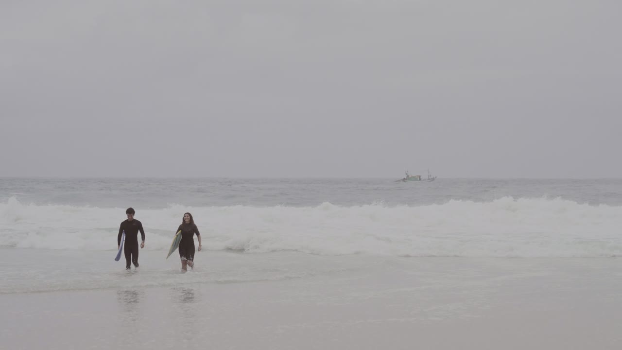 Two Surfers Walking into the Ocean with Boards