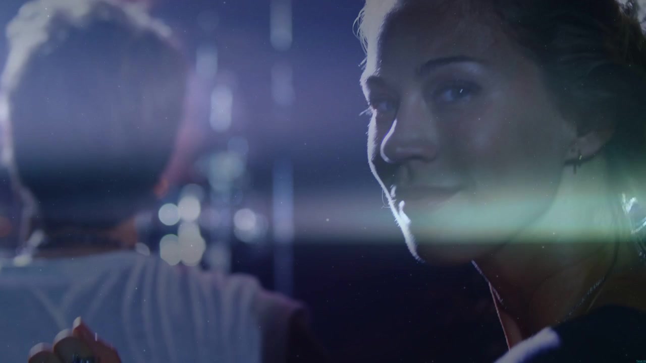 Camera moving closer while woman turning toward camera in nightlife, lens flares highlighting ring