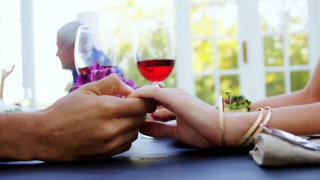 Couple-holding-hands-in-restaurant