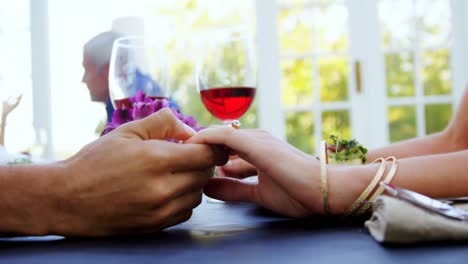 pareja cogida de la mano en un restaurante