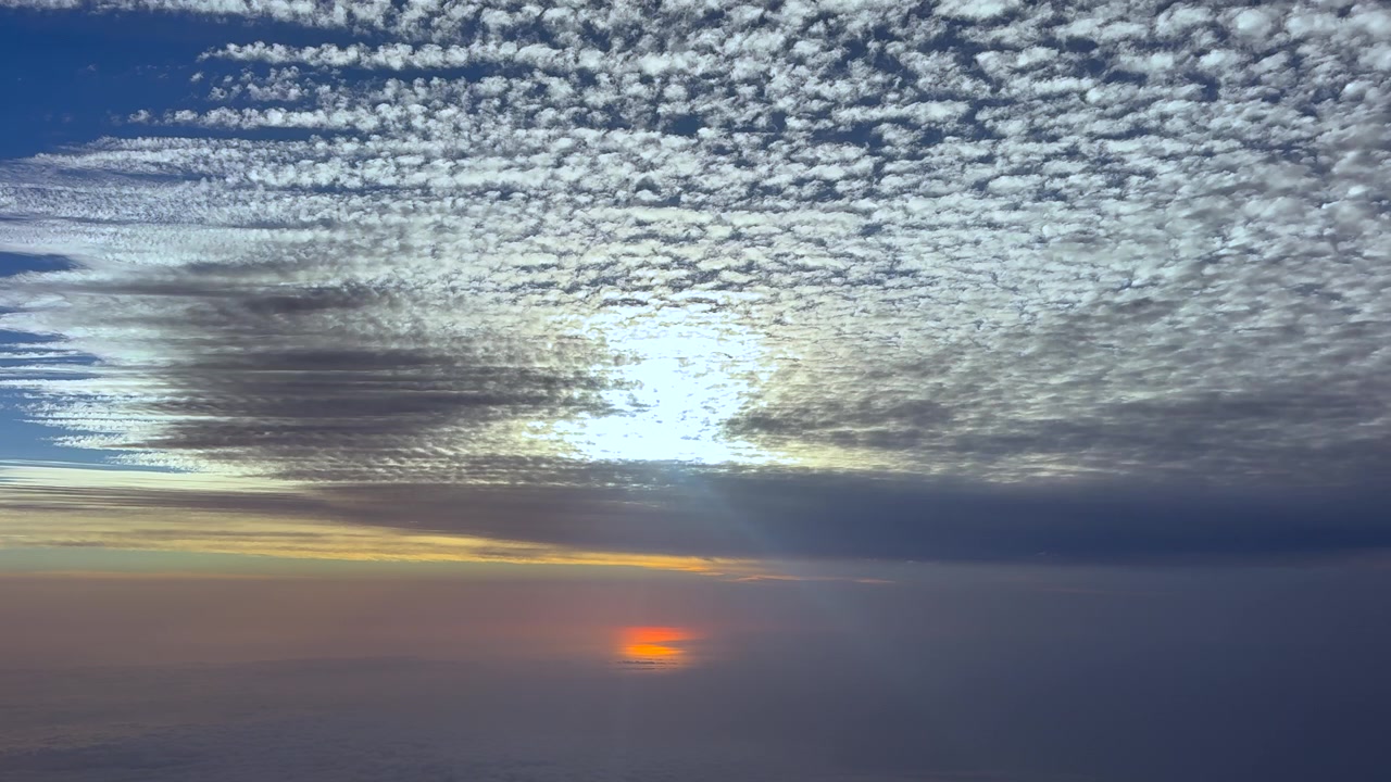 Left side cockpit view of a layer of cloud streets at sunrise captured over the Mediterranean sea. 4K shot.