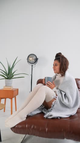 woman relaxing on sofa with a hot drink