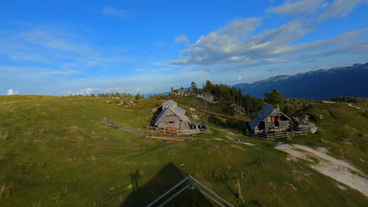 las imágenes de fpv se filmaron en el pueblo de montaña esloveno en los alpes con un dron volando rápido sobre montañas filmadas con una gopro con paisajes circundantes volando entre y sobre pequeñas cabañas de madera-2