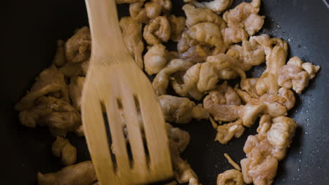 cooking sliced chicken in a pan