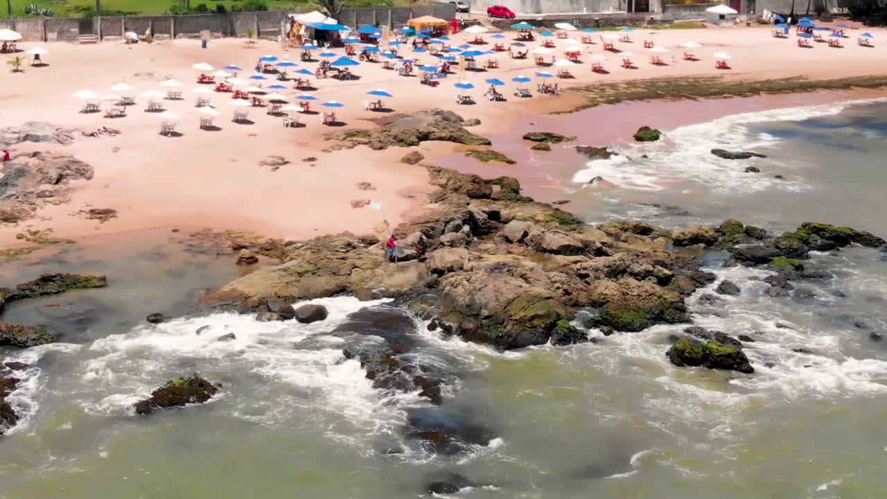 dron volando de izquierda a derecha sobre una roca en la orilla