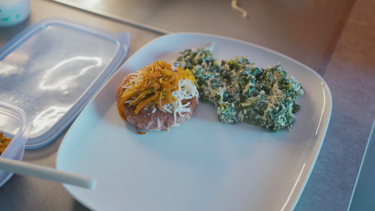 cocinar lugares de hamburguesas con queso, cebolla y pimientos en un plato