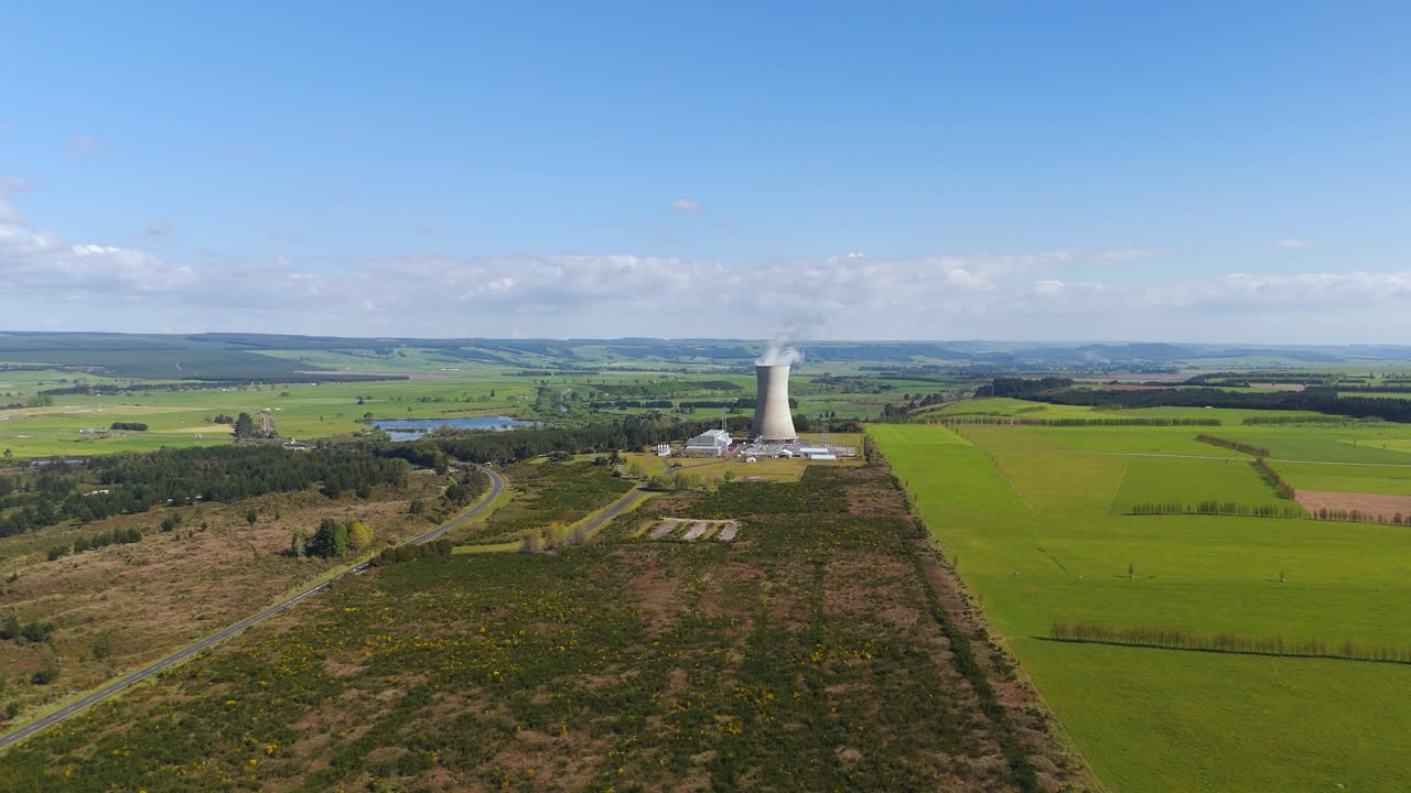 Geothermalkraftwerk Ohaaki in Waikato, Neuseeland: Kühlturm stößt Dampf über ländlichem Ackerland aus. Konzept für erneuerbare Energie und sauberen Strom, filmische Luftaufnahme