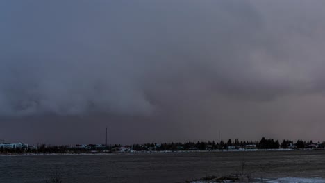 time lapse storm clouds passing over a town in iceland, from dark and gloomy to sunny again
