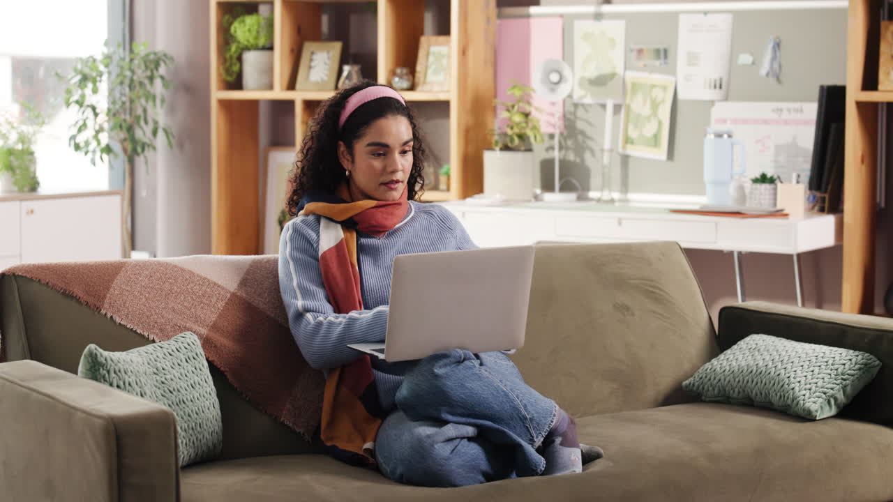 Woman using laptop on couch at home