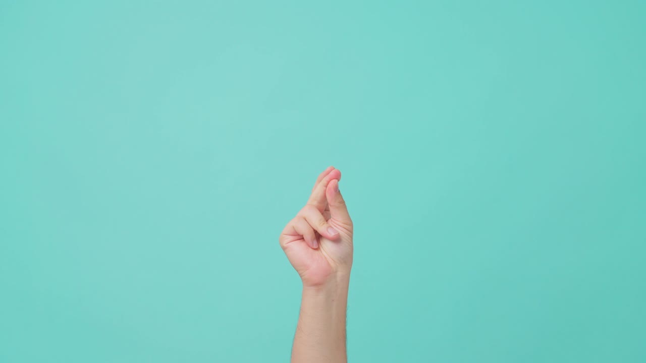 toma de primer plano de la mano humana levantando, con el gesto de chasquido del dedo. el hombre chasqueando el dedo tratando de hacer un sonido para atraer la atención de la gente. visto en pantalla azul aislada en el fondo.