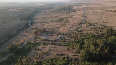 Paso-Elevado-De-Drones,-Carretera-Con-Curvas-En-El-Campo-Con-Tráfico-De-Vehículos,-Día-Soleado