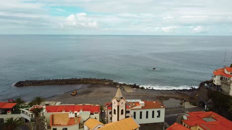 drone sobre el extremo de la playa del sol con cielo azul y mar de la isla de madeira