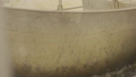 producción de papas fritas y bocadillos. máquina industrial de fritura profunda. las papas fritas se fríen en un cuenco grande con aceite. la línea de producción de la fábrica mueve las papas frias doradas después de freír.