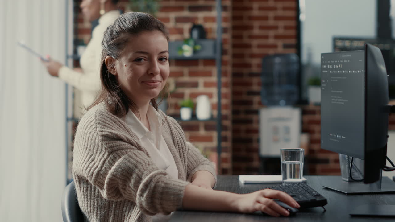Programer typing source code on computer keyboard turning head and smiling