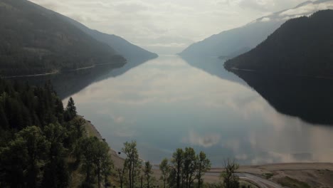 slow aerial dolly over slocan lake with a slight mist