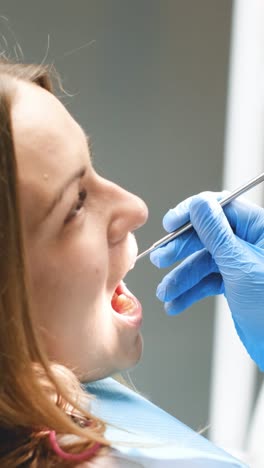 a woman is being examined by a dentist in a dental clinic.