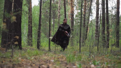 Medieval-bearded-scout-with-bow-looks-for-enemies-in-forest