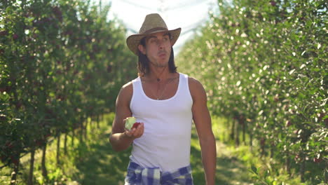 Man Eating an Apple in a Sunny Orchard