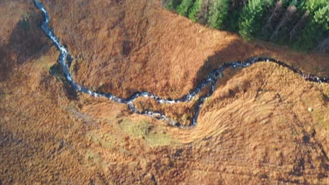 aerial footage towards ranch moor in the highlands of scotland starting top down and rising to reveal mountains